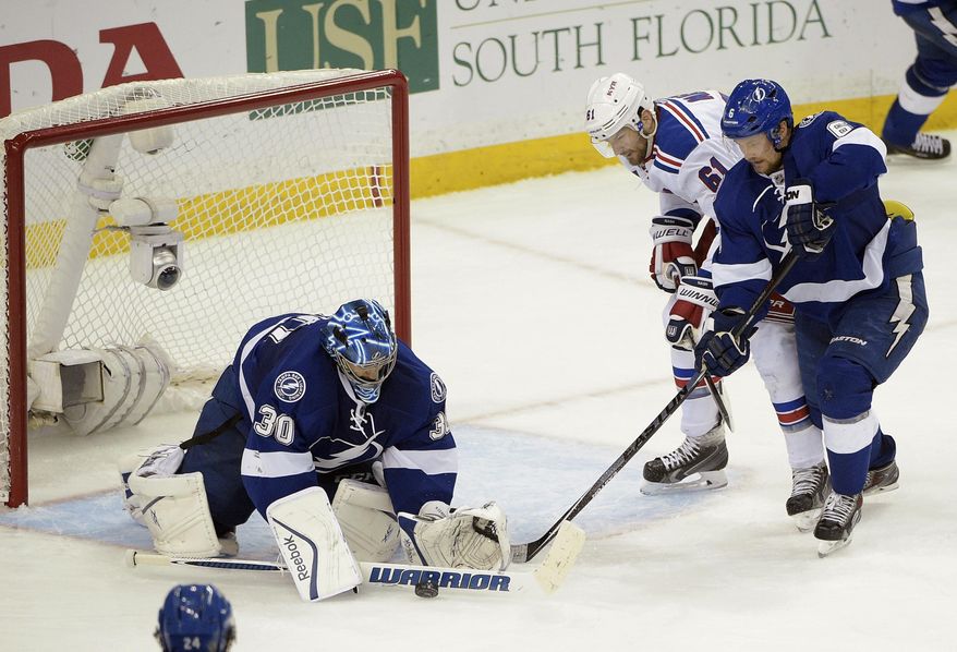 Tampa Bay Lightning goalie Ben Bishop (30) stops a shot as New York Rangers left wing Rick Nash (61) and Tampa Bay Lightning defenseman Anton Stralman (6), of Sweden, look for a rebound during the second period of Game 6 of the Eastern Conference finals in the NHL hockey Stanley Cup playoffs,Tuesday, May 26, 2015, in Tampa, Fla. (AP Photo/Phelan M. Ebenhack)