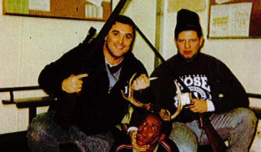 This photo, believed to have been taken between 1999 and 2003, provided by the Cook County Court, in Illinois, shows an image of Chicago Police Officers Jerome Finnigan, left, and Timothy McDermott, right, with an unidentified man, that was made public after McDermott filed a lawsuit in Cook County Circuit Court seeking to rejoin the Chicago Police Department. The Chicago Police Board fired McDermott in October 2014 after finding him guilty of bringing discredit on the department by taking part in the photo, disrespecting or maltreating a person on or off duty, and unlawful or unnecessary use or display of a weapon. (Courtesy of Cook County Court via AP)