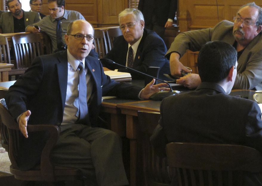 Kansas state Rep. Steve Brunk, R-Wichita, left, makes a point about tax issues during a meeting of House Republicans, Thursday May 28, 2015, at the Statehouse in Topeka, Kan. Brunk and other GOP conservatives fear losing influence over tax policy when House and Senate negotiators begin work on the final version of a bill to raise taxes. (AP Photo/John Hanna)
