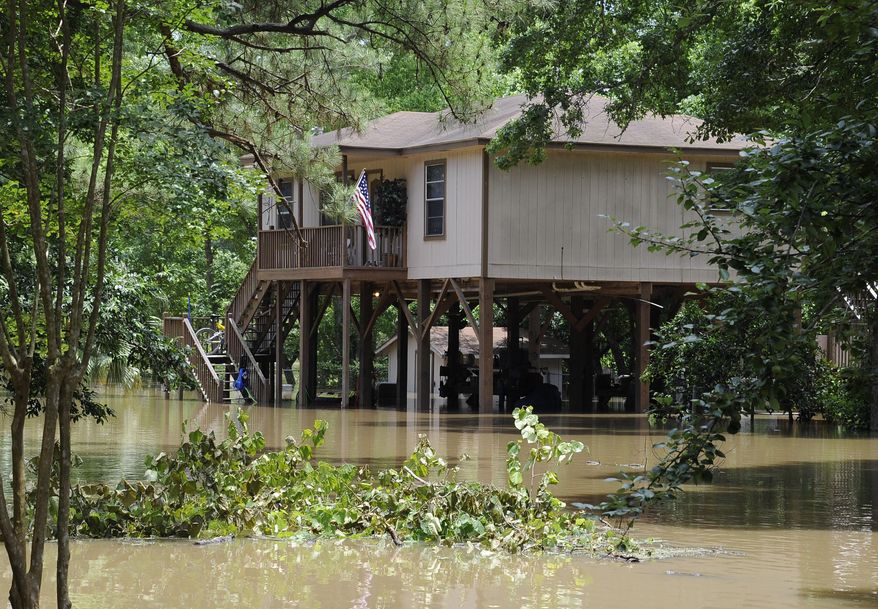 A house built on tall piers is surrounded by flood water from the San Jacinto River Thursday, May 28, 2015, in Kingwood, Texas. Although the deadly thunderstorms that lashed much of Texas have tapered off, many cities were still in danger of flooding Thursday as heavy rain from earlier in the week poured downstream, swelling rivers. (AP Photo/Pat Sullivan)