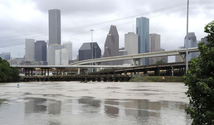 Flood waters overrun the banks of the bayou in downtown Houston, Tuesday, May 26, 2015. Floodwaters kept rising Tuesday across much of Texas as storms dumped almost another foot of rain on the Houston area, stranding hundreds of motorists and inundating the famously congested highways that serve the nation’s fourth-largest city. (AP Photo/Pat Sullivan)