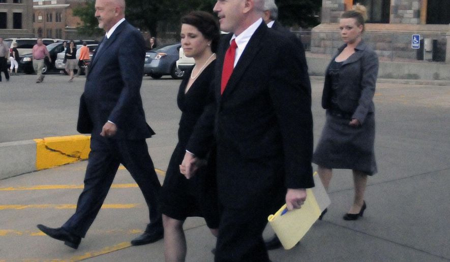 CORRECTS SOURCE - Former Republican U.S. Senate candidate Annette Bosworth, center, walks towards a vehicle from the Hughes County Courthouse in Pierre, S.D., on Wednesday, May 27, 2015, with her husband, Chad Haber, right, and her defense attorney, Dana Hanna, left. A South Dakota jury on Wednesday convicted former U.S. Senate candidate Annette Bosworth of election law violations. (AP Photo/James Nord)