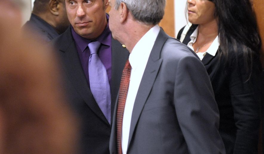 Defendant former Inkster police officer William Melendez, left, enters 22nd District Court for a pre trial exam Thursday, May 28, 2015, in Inkster, Mich. Melendez, who is accused of repeatedly punching driver Floyd Dent in the head during a traffic stop, was ordered to stand trial on assault charges. (Todd McInturf/The Detroit News via AP)