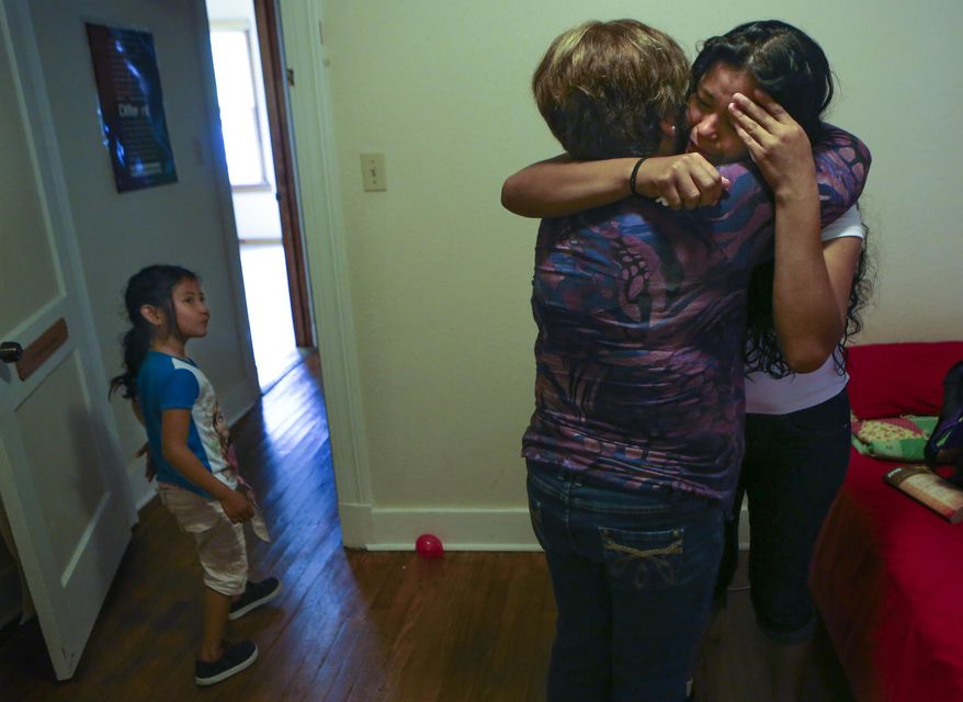 Mirian Escobar Perez, 23, far right, of Honduras cries and is comforted by Rosie at the Mennonite Casa de Maria y Marta shelter on Monday, April 2, 2015 in San Antonio, Texas. The Mennonite Casa de Maria y Marta is where immigrant women and their children stay after being released from detention centers in South Texas and participates as part of the Interfaith Welcome Coalition. (Bob Owen/The San Antonio Express-News via AP) RUMBO DE SAN ANTONIO OUT; NO SALES
