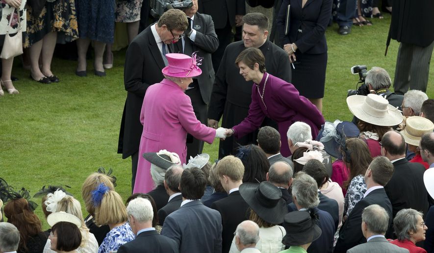 Britain's Queen Elizabeth II, centre left greets Libby Lane, the Bishop of Stockport, who is the first female bishop in the English Anglican church, during a garden party at Buckingham Palace in London, Thursday, May 28, 2015. (AP Photo/Alastair Grant, Pool)