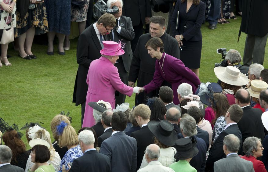 Britain's Queen Elizabeth II, centre left greets Libby Lane, the Bishop of Stockport, who is the first female bishop in the English Anglican church, during a garden party at Buckingham Palace in London, Thursday, May 28, 2015. (AP Photo/Alastair Grant, Pool)