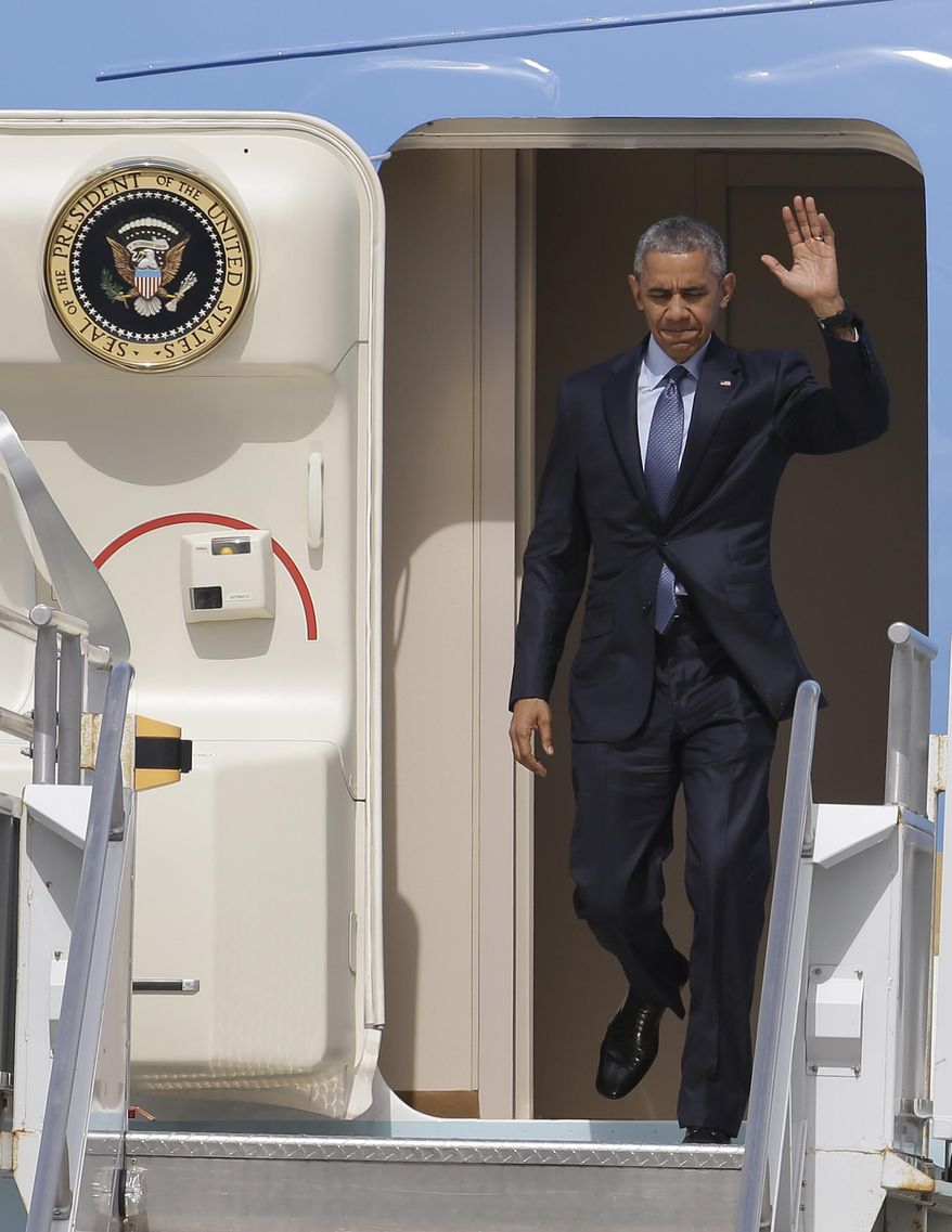 President Barack Obama waves as he disembarks from Air Force One at Miami International Airport, Wednesday, May 27, 2015, in Miami. The president is attending two Democratic National Committee fundraisers and the National Hurricane Center in this overnight visit. (AP Photo/Lynne Sladky)