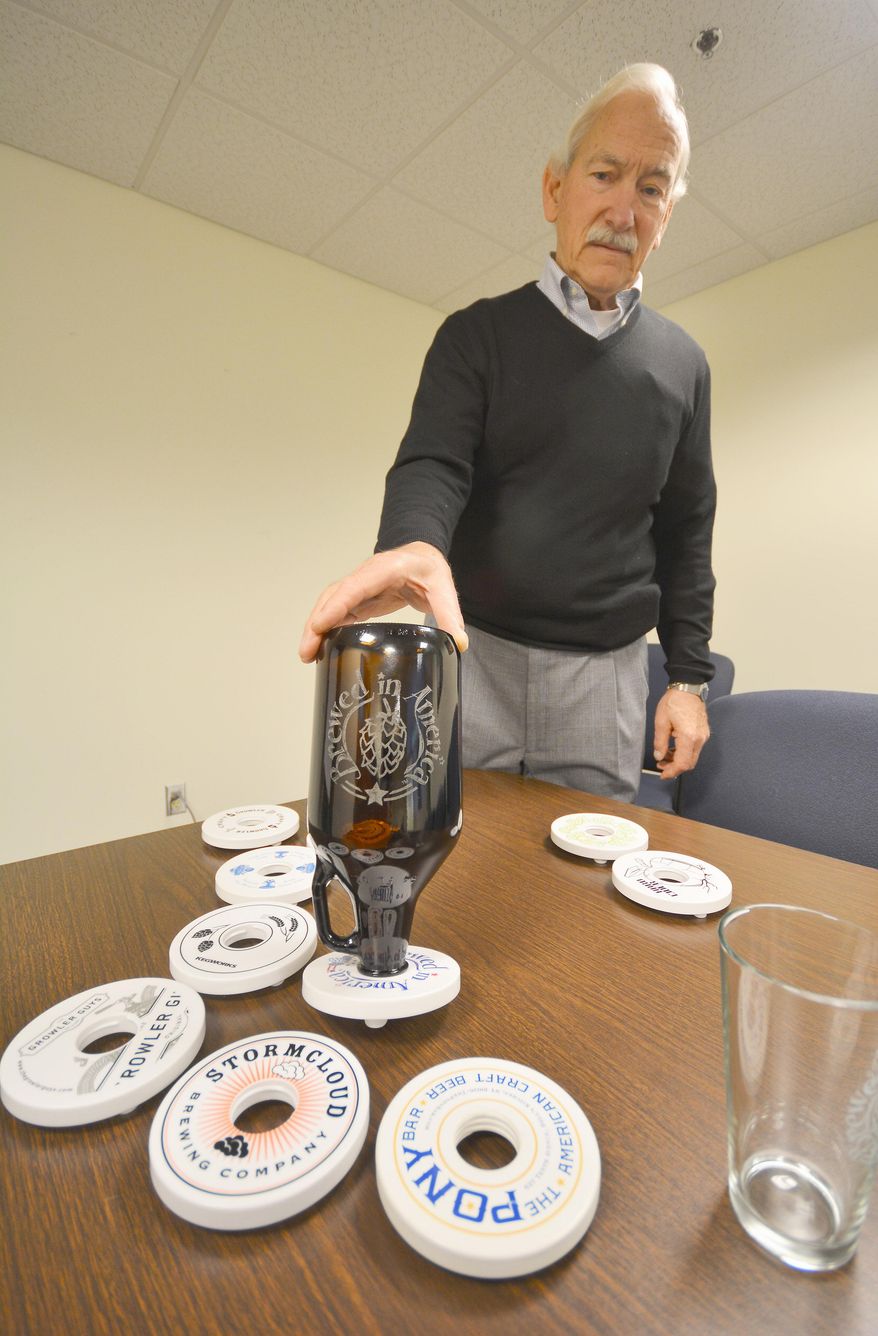 ADVANCE FOR MONDAY, JUNE 1 AND THEREAFTER - In a May 12, 2015 photo, Staton Lorenz demonstrates his invention, the Growler Collar, in Traverse City, Mich. Lorenz found that purchasing, transporting and drinking beer in growlers was easy. Washing them was not. The dilemma led to an invention, a patented design and a business. (Dan Nielsen/The Record-Eagle via AP) MANDATORY CREDIT