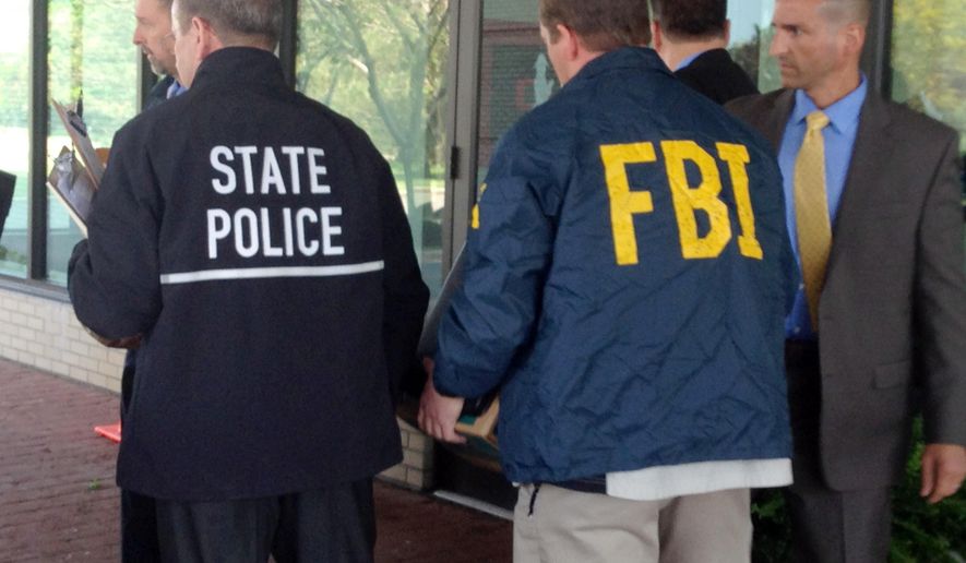 New York state and federal law enforcement officers remove boxes from the Buffalo, N.Y., residence of Steven Pigeon, a former Erie County Democratic Party chairman, on May 28, 2015. In addition to Pigeon's condominium, authorities, who declined to comment on the investigation, also executed search warrants at the homes of former Buffalo Deputy Mayor Stephen Casey and Christopher Grant, chief of staff to U.S. Rep. Chris Collins. (AP Photo/Carolyn Thompson)