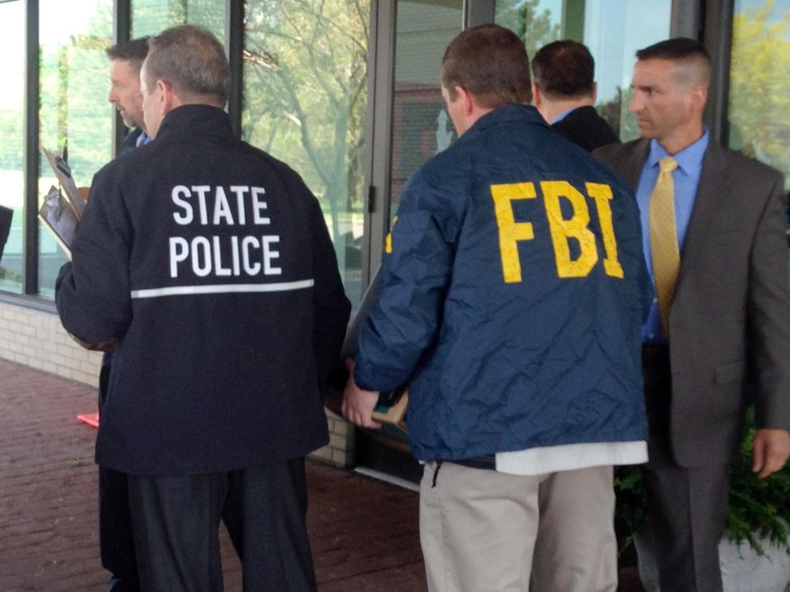 New York state and federal law enforcement officers remove boxes from the Buffalo, N.Y., residence of Steven Pigeon, a former Erie County Democratic Party chairman, on May 28, 2015. In addition to Pigeon's condominium, authorities, who declined to comment on the investigation, also executed search warrants at the homes of former Buffalo Deputy Mayor Stephen Casey and Christopher Grant, chief of staff to U.S. Rep. Chris Collins. (AP Photo/Carolyn Thompson)