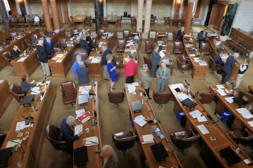 Nebraska lawmakers interact in the Legislative Chamber in Lincoln, Neb., Friday, May 29, 2015, on the last day of a legislative session that included a gas tax increase, the repeal of a ban on driver's licenses for young immigrants and the abolition of the death penalty. (AP Photo/Nati Harnik)