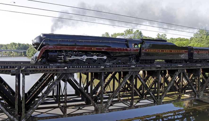 The Norfolk & Western Class J No. 611 steam locomotive crosses a bridge over the Yadkin River after leaving the North Carolina Transportation Museum in Spencer, N.C., Saturday, May 30, 2015. The train, which has undergone a year-long restoration, is returning to the Virginia Museum of Transportation in Roanoke, Virginia. (AP Photo/Chuck Burton)