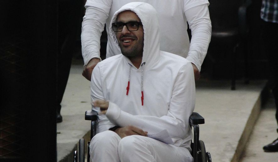 In this March 9, 2015 photo, Mohammed Soltan is pushed by his father Salah during a court appearance in Cairo, Egypt. Egyptian officials say authorities have freed Soltan, a dual U.S.-Egyptian citizen, Saturday May 30, 2015, Soltan had been sentenced to life in prison on charges of financing an anti-government sit-in and spreading "false news." (AP Photo/Heba Elkholy) ***EGYPT OUT***