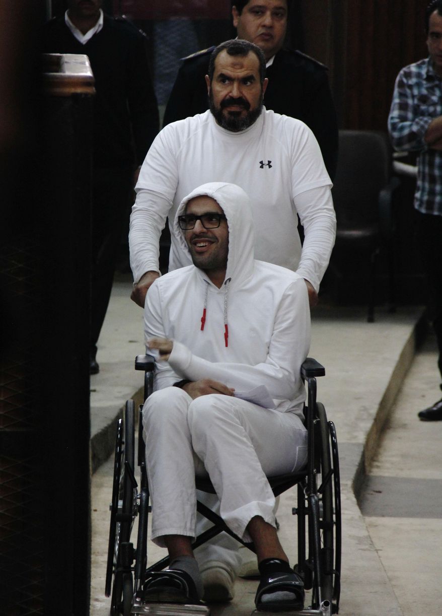 In this March 9, 2015 photo, Mohammed Soltan is pushed by his father Salah during a court appearance in Cairo, Egypt. Egyptian officials say authorities have freed Soltan, a dual U.S.-Egyptian citizen, Saturday May 30, 2015, Soltan had been sentenced to life in prison on charges of financing an anti-government sit-in and spreading "false news." (AP Photo/Heba Elkholy) ***EGYPT OUT***