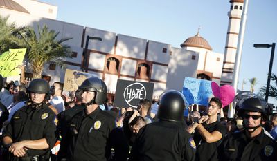 Protesters gather outside the Islamic Community Center of Phoenix, Friday, May 29, 2015. About 500 protesters gathered outside the Phoenix mosque on Friday as police kept two groups sparring about Islam far apart from each other.  (AP Photo/Rick Scuteri)