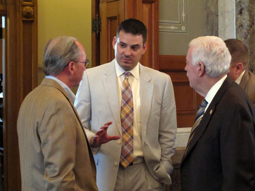 Wade Hapgood, center, chief of staff to Kansas House Speaker Ray Merrick, R-Stilwell, confers with Merrick, right, and Rep. Marvin Kleeb, left, R-Overland Park, during a break in the chamber's session, Sunday, May 31, 2015, at the Statehouse in Topeka, Kan. It was Hapgood's last day on the job, before he moves into a position with a health insurance company. (AP Photo/John Hanna)