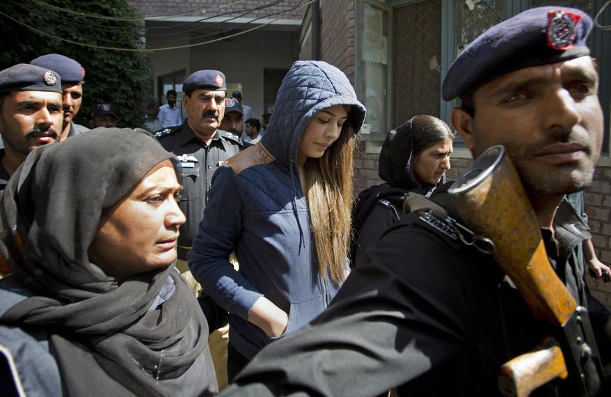 Pakistan's top model, Ayaan Ali, center, arrives in tight security to appear in a court in Rawalpindi, Pakistan, Monday, June 1, 2015. Ali is under detention since her midnight arrest on March 14 at Islamabad airport and faces money laundering charges after authorities seized over $500,000 before she boarded a Dubai-bound flight. Pakistani law makes it illegal for a passenger carry over $10,000 on a flight. (AP Photo/B.K. Bangash)