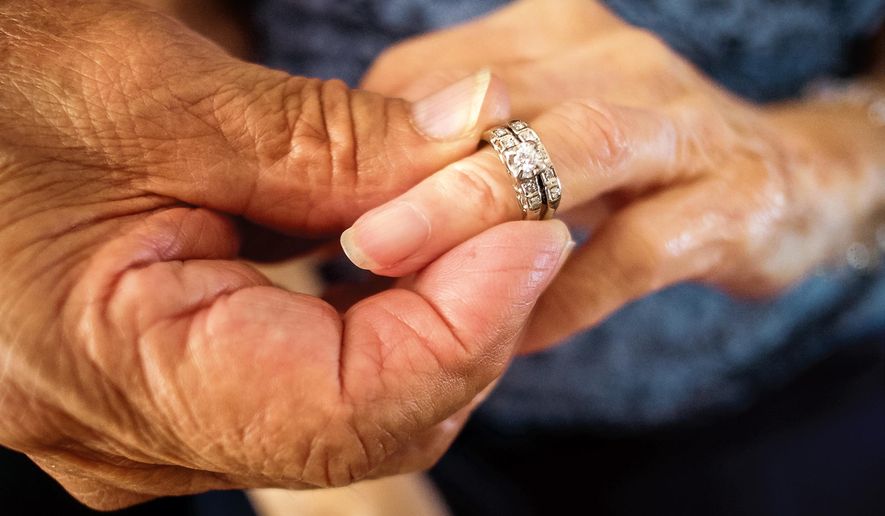 Robert Kirker puts a wedding ring, lost for 30 years, on his wife Ofelia's hand at their home in Las Cruces, N.M., May 27, 2015. It's been decades since Ofelia Kirker lost her wedding rings, but she'll be wearing the treasured jewelry for her 64th wedding anniversary. The rings were unearthed in a yard there years ago and have finally made their way back to her thanks to an observant yard worker, one woman's sharp memory and her daughter's persistence. (Jett Lowe/Las Cruces Sun-News via AP) MANDATORY CREDIT