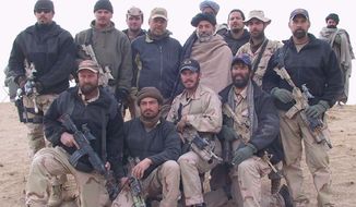 A photo of Army Lt. Col. Jason Amerine and his team with Afghan freedom fighters in 2001. Col. Amerine is in the first row, second from the right. The turbaned man standing in the second row is Hamid Karzai, who later became Afghanistan&#39;s first democratically elected president.