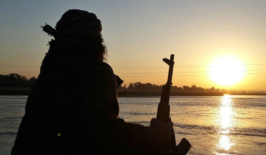 An Islamic State member rests along the Euphrates River in Raqqa, Syria. (Associated Press) ** FILE **