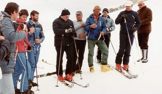 Pope John Paul II (center, in red boots) prays with a group of skiers before heading down a slope in this 1984 file photo. (CNS photo from the Vatican) (Feb. 10, 2005)