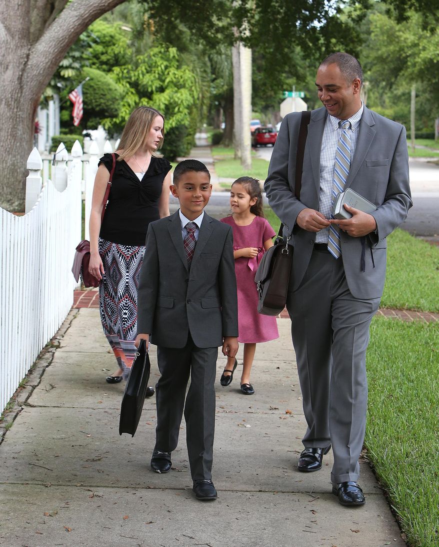 ADVANCE FOR THE WEEKEND OF JUNE 6-7 AND THEREAFTER - In a April 24, 2105 photo, members of the Mitchell family, of Riverview, Fla., walk along 25th Ave. in North, St. Petersburg, Fla., as they stop at various homes in the Crescent Heights neighborhood to share Bible verses and pass out Jehovah Witnesses literature. Front left to right: Devin Mitchell, Jared Mitchell. Back left to right: Angela Mitchell and Mya Mitchell. The Witnesses fully acknowledge they are the last of a thinning breed: door-to-door, face-to-face salesmen, shoe-leather agents in a guarded age when technology, social media and cyber-dependence are making more and more transactions devoid of human contact. (Scott Keeler/Tampa Bay TImes via AP)