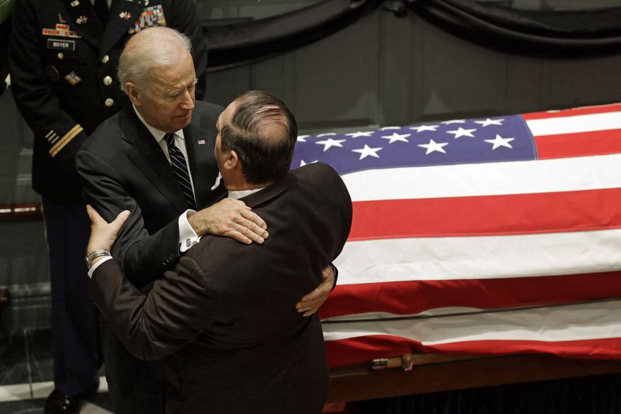 Vice President Joe Biden, left, hugs a mourner as they stand near a casket containing the remains of Biden&#x27;s son, former Delaware Attorney General Beau Biden, during a viewing, Thursday, June 4, 2015, at Legislative Hall in Dover, Del. Beau Biden died of brain cancer Saturday at age 46. (AP Photo/Patrick Semansky)