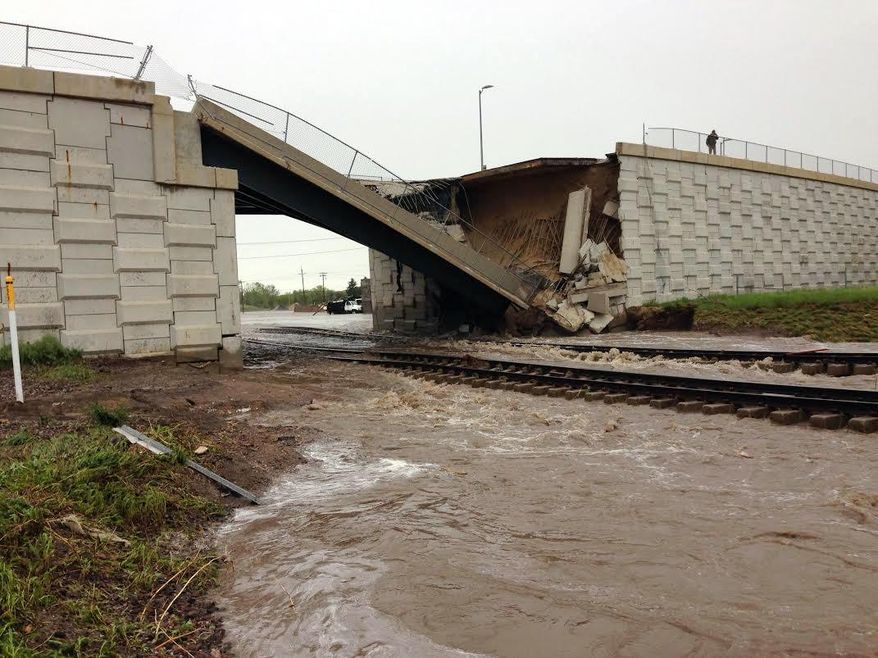 This photo provided by the Wyoming Highway Patrol shows a portion of a bridge over railroad tracks on the north side of the small eastern Wyoming town of Lusk that was collapsed by flash flood waters early Thursday. June 4, 2015. Up to 6 inches of rain fell in the area overnight Wednesday and early Thursday, forcing some residents to leave their homes and causing damage to area highways. (Wyoming Highway Patrol via AP))