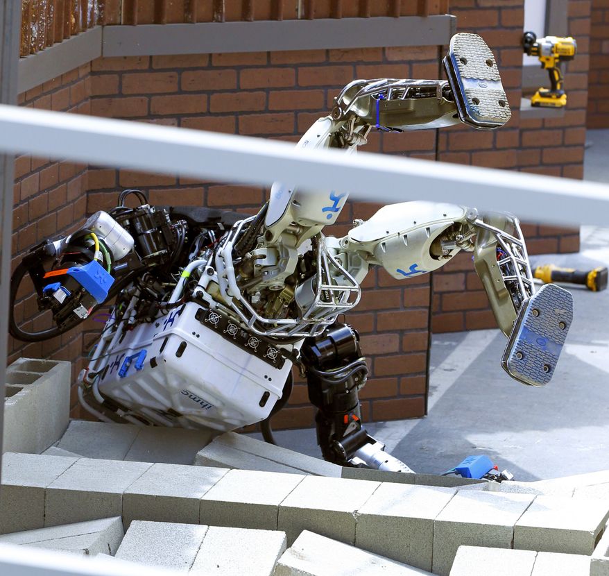 Robot Running Man from the Florida Institute for Human and Machine Cognition takes a tumble during the competition in the U.S. Defense Advanced Research Projects Agency Robotics Challenge in Pomona, Calif., Friday, June 5, 2015. Robots from 24 teams are taking part in a two-day contest hosted by the U.S. Defense Advanced Research Projects Agency, DARPA, to prove their performance in different tasks during a simulated disaster course. (AP Photo/Alex Gallardo) ** FILE **