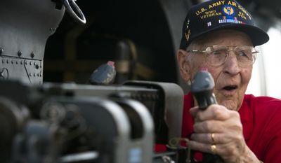 Jim Kirk, a World War II veteran and B-17G ball turret gunner, reacts to holding a 50-cal. machine gun during the Gathering of Eagles event on Friday, June 5, 2015, at Maxwell Air Force Base in Montgomery, Ala. (Albert Cesare/The Montgomery Advertiser via AP)