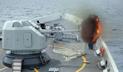 An anti-surface gunnery is fired from China&#39;s Navy missile frigate Yulin during the &quot;Exercise Maritime Cooperation&quot; by Singapore and Chinese navies in the South China Sea, May 24, 2015. (Bao Xuelin/Xinua via AP, File) ** FILE **