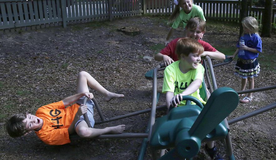 In this Friday, June 5, 2015 photo, 10-year-old Gabe Griffin, center, plays with his family, from left, William Blessey, 8, Cooper Griffin, 11, Elizabeth Blessey, 9, and Caroline Blessey, 6, in Birmingham, Ala. Griffin suffers from Duchenne Muscular Dystrophy, a rare muscular degenerative disease that gradually and then rapidly leads to incapacitation before ultimately to an early death. A new Alabama law passed during the 2015 legislative session seeks to allow terminally ill patients to try drugs that have passed the first clinical trial but that haven’t been approved by the U.S. Food and Drug Administration. (AP Photo/Brynn Anderson)