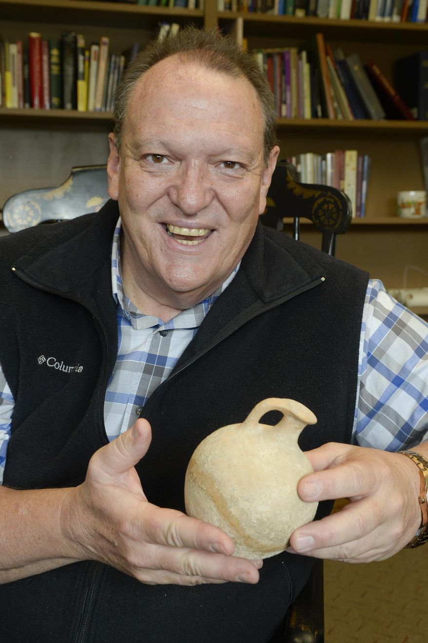 Rev. David Cox holds archaeological artifacts on May 26, 2015 in Norfolk, Neb. Before becoming a pastor, Cox studied archaeology at Western Washington University, formerly Western Washington State College. (Darin Epperly/The Norfolk Daily News via AP)