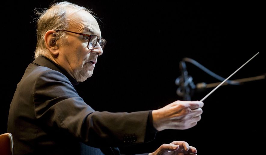 FILE -- In this Feb. 15, 2014 file photo Italian composer Ennio Morricone conducts the Modern Art Orchestra of Hungary during a concert of his film scores in Papp Laszlo Budapest Sports Arena in Budapest. Oscar-winning Italian composer Ennio Morricone this week will premiere a Mass he composed to mark the 200th anniversary of the restoration of the Jesuit order and named for its most illustrious member, Pope Francis. (AP Photo/MTI, Balazs Mohai, File)