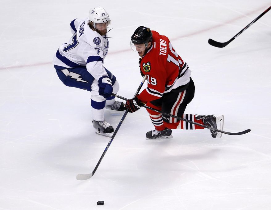 Chicago Blackhawks&#x27; Jonathan Toews, right, handles the puck as Tampa Bay Lightning&#x27;s Victor Hedman, of Sweden, defends during the first period in Game 3 of the NHL hockey Stanley Cup Final on Monday, June 8, 2015, in Chicago. (AP Photo/Charles Rex Arbogast)