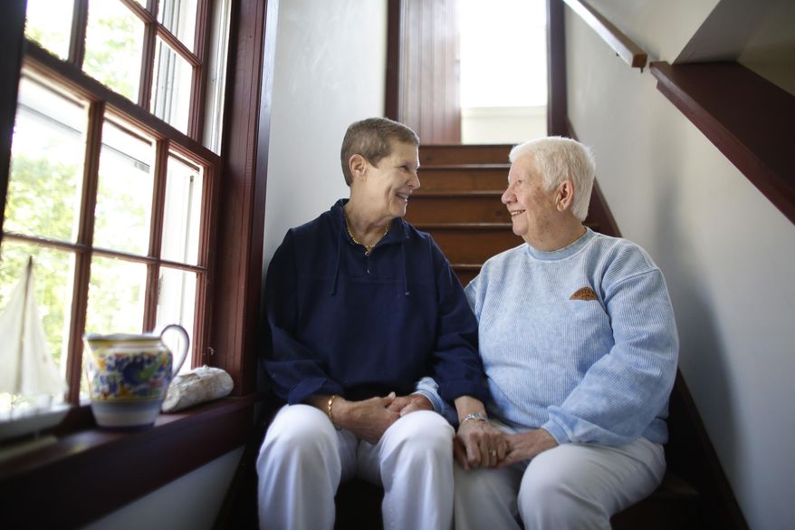In this Thursday, June 4, 2015 photo married couple Linda Bailey-Davies, 69, left, and Gloria Bailey-Davies, 74, both of Orleans, Mass., sit together for a photo in their home, in Orleans. As the U.S. Supreme Court ponders the future of same-sex marriage, Massachusetts, the first state to legalize gay marriage, offers a decade-long real world test of what happens when gay couples can legally marry. (AP Photo/Steven Senne)