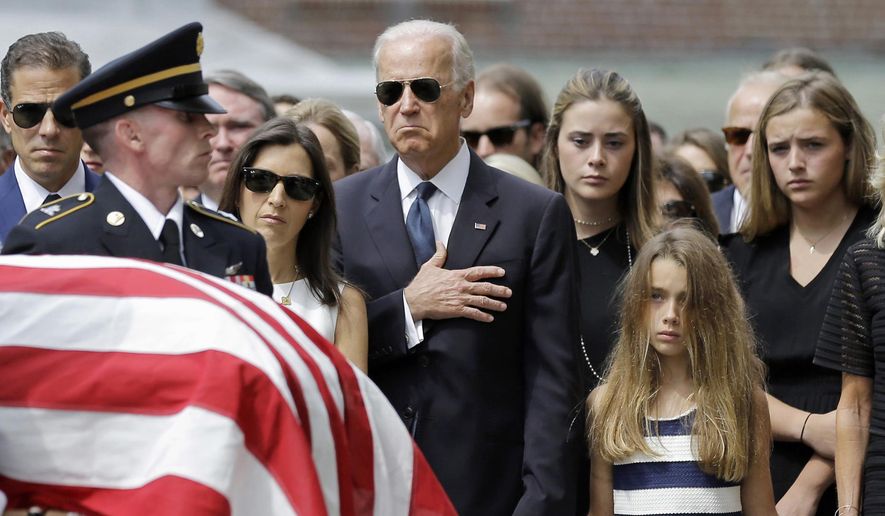 In this June 6, 2015, file photo, Vice President Joe Biden, accompanied by his family, holds his hand over his heart as he watches an honor guard carry a casket containing the remains of his son, former Delaware Attorney General Beau Biden, into St. Anthony of Padua Roman Catholic Church in Wilmington, Del., for funeral services. (AP Photo/Patrick Semansky)