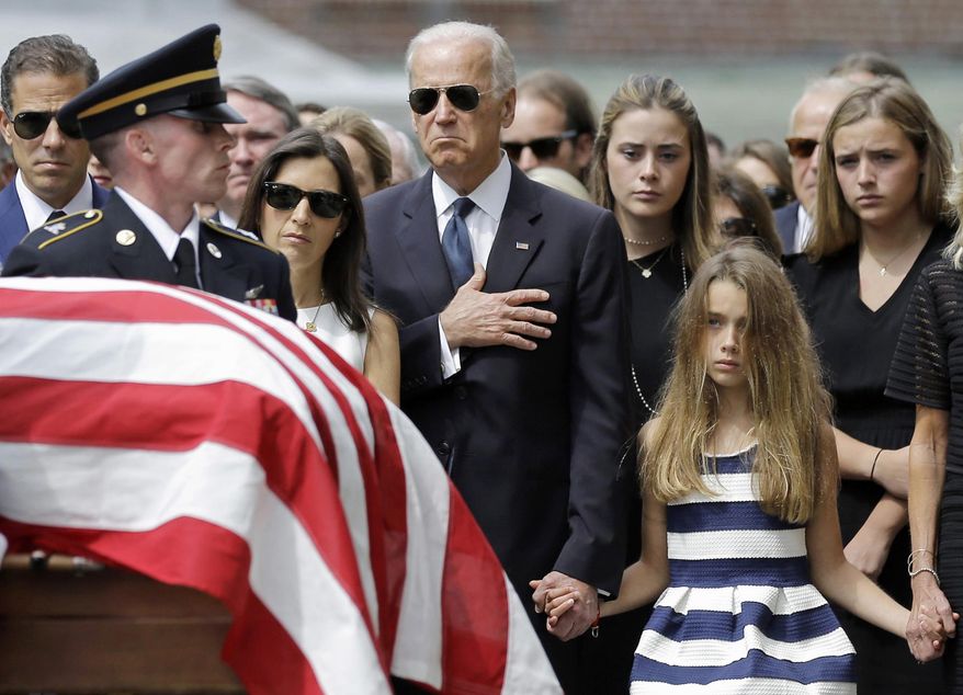 In this June 6, 2015, file photo, Vice President Joe Biden, accompanied by his family, holds his hand over his heart as he watches an honor guard carry a casket containing the remains of his son, former Delaware Attorney General Beau Biden, into St. Anthony of Padua Roman Catholic Church in Wilmington, Del., for funeral services. (AP Photo/Patrick Semansky)