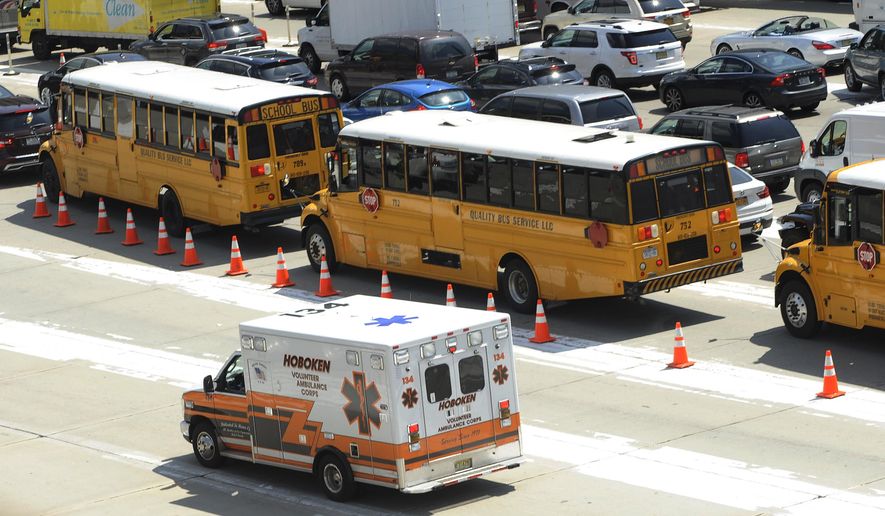 An ambulance rushes by congested traffic on the New Jersey side of the Lincoln Tunnel in Weehawken, N.J., Wednesday, June 10, 2015. A New Jersey transit bus rear-ended a private bus injuring at least 18 people at around 9:30 a.m. in the center tube on the New York side of the tunnel connecting it with New Jersey, according to a spokesman for the Port Authority of New York and New Jersey police. (AP Photo/Joe Epstein)