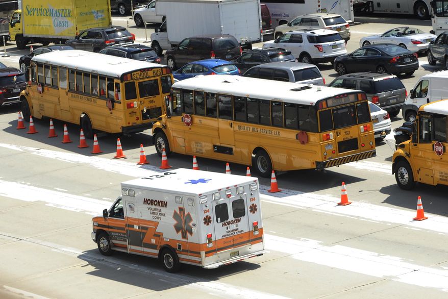 An ambulance rushes by congested traffic on the New Jersey side of the Lincoln Tunnel in Weehawken, N.J., Wednesday, June 10, 2015. A New Jersey transit bus rear-ended a private bus injuring at least 18 people at around 9:30 a.m. in the center tube on the New York side of the tunnel connecting it with New Jersey, according to a spokesman for the Port Authority of New York and New Jersey police. (AP Photo/Joe Epstein)