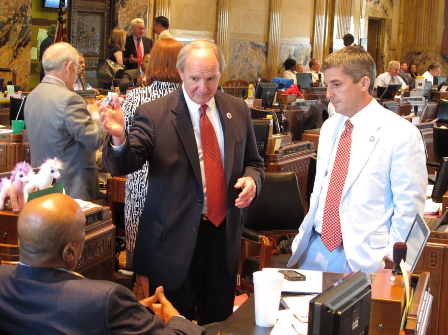 Sen. Robert Adley, R-Benton, center, speaks with Rep. Terry Landry, D-New Iberia, sitting, and Rep. Cameron Henry, R-Metairie, right, about a proposal to raise the vehicle title fee on car buyers by $50, Thursday, June 11, 2015. The fee hike was part of the broader budget negotiations on the final day of the regular legislative session. (AP Photo/Melinda Deslatte)
