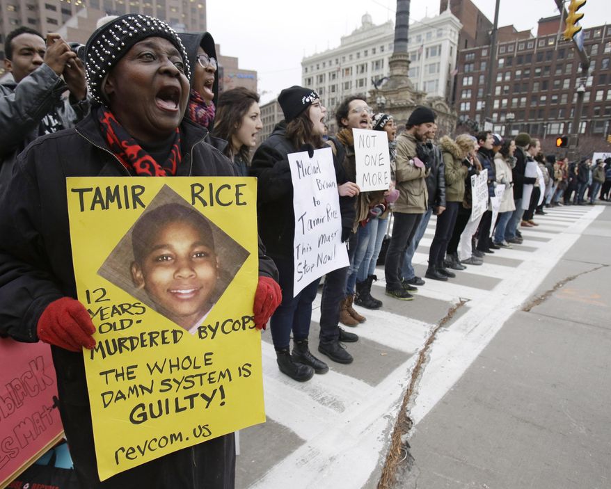 FILE- In this Nov. 25, 2014, file photo, demonstrators block Public Square in Cleveland, during a protest over the police shooting of 12-year-old Tamir Rice. A judge has ruled that evidence exists to charge two police officers in the fatal shooting of a 12-year-old boy who was holding a pellet gun outside a recreation center, Thursday, June 11, 2015. (AP Photo/Tony Dejak, File)