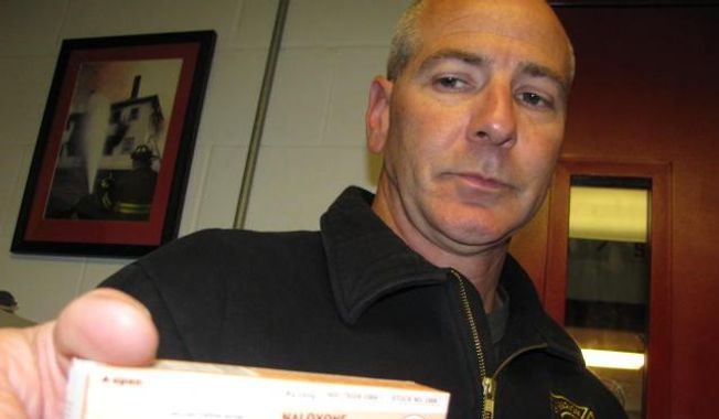 In this photo taken June 1, 2015, Marion Fire Department Capt. Wade Ralph shows a dose of naloxone, used by emergency crews to revive overdosing heroin users in Marion, Ohio. The life-saving drug was used repeatedly when a super-charged batch of heroin led to more than 30 overdoses in an 11-day period at the end of May in the small Ohio city. (AP Photo/Mitch Stacy)