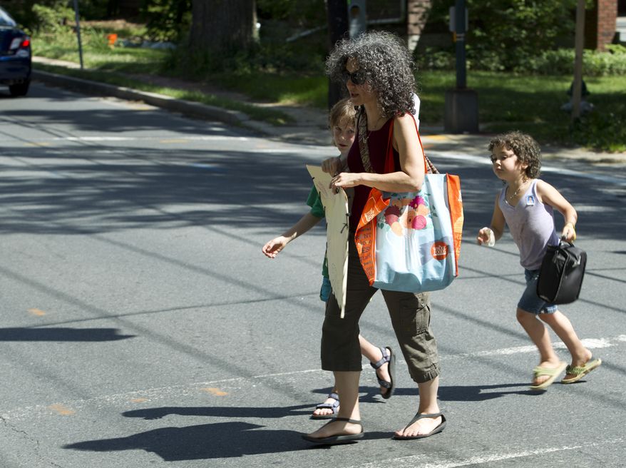 Danielle Meitiv walks home with her children Rafi, 10, left and Dvora, 6, right, after picking them up at the school bus stop in Silver Spring Md., on Friday, June 12, 2015. After outcry over one family’s “free-range” parenting case, Maryland officials on Friday clarified the state’s policy on how authorities handle cases of children walking or playing alone outdoors, saying the state shouldn’t investigate unless kids are harmed or face substantial risk of harm. (AP Photo/Jose Luis Magana)