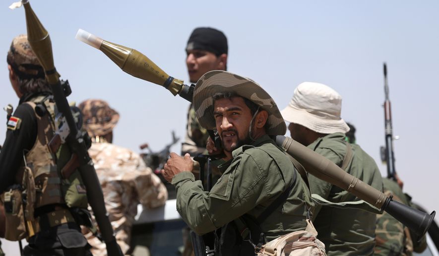Fighters from the Badr Brigades Shiite militia patrol at the front line, in Kessarrat, located (70 kilometers) north west of Baghdad, Iraq, Friday, June 12, 2015. Despite concerns over heightened sectarian strife, Shiite militiamen continue to pour into Iraq’s Anbar province with the hope of recapturing the city of Fallujah from the Islamic State group. As the U.S. prepares to send an additional 450 trainers to Iraq, the Iranian-backed militias say that coalition assistance only hurts their efforts, contradicting statements by the Iraqi government that more international support is needed. (AP Photo/Hadi Mizban)