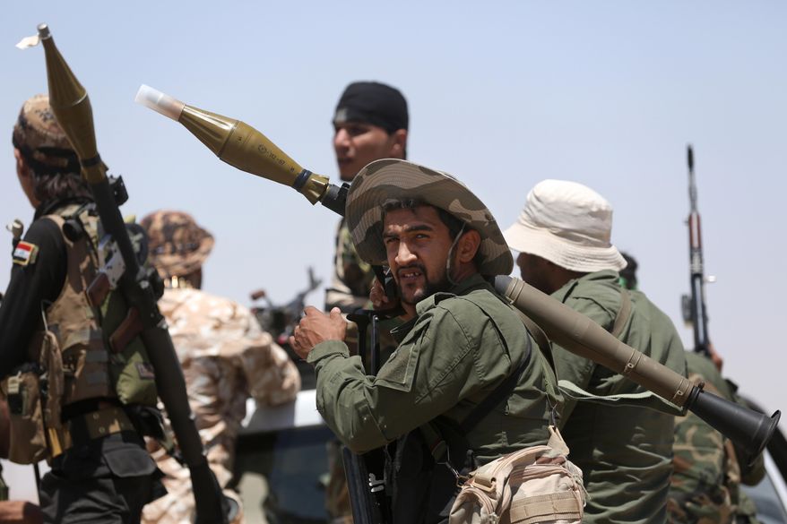 Fighters from the Badr Brigades Shiite militia patrol at the front line, in Kessarrat, located (70 kilometers) north west of Baghdad, Iraq, Friday, June 12, 2015. Despite concerns over heightened sectarian strife, Shiite militiamen continue to pour into Iraq’s Anbar province with the hope of recapturing the city of Fallujah from the Islamic State group. As the U.S. prepares to send an additional 450 trainers to Iraq, the Iranian-backed militias say that coalition assistance only hurts their efforts, contradicting statements by the Iraqi government that more international support is needed. (AP Photo/Hadi Mizban)