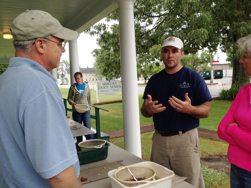 ADVANCE FOR SUNDAY, JUNE 14, 2015 - In this photo taken Friday, June 5, 2015, Dr. David Brown, with the Fairfield Foundation in Gloucester, prepares volunteers to wash artifacts at the Middlesex County Museum in Middlesex, Va. The artifacts were discovered during a dig last summer at the location of the Old Customs House, which was home to Andrew Jackson Montague, Virginia's 44th governor. (Frances Hubbard/The Daily Press via AP)
