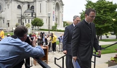 Auxiliary Bishop Andrew Cozzens, right, and Tom Halden, director of communications for the Archdiocese of Saint Paul &amp; Minneapolis, walk back to the chancery after announcing the resignations of Archbishop John Nienstedt and Auxiliary Bishop Lee Anthony Piche during a news conference at the Archdiocese of Saint Paul &amp; Minneapolis Chancery in St. Paul Minn., Monday, June 15, 2015.  In the last two years, Nienstedt was besieged by a clergy sex-abuse scandal that included numerous lawsuits from victims and led to bankruptcy. Then earlier this month, the archdiocese was criminally charged with failing to protect children. (AP Photo/Craig Lassig)
