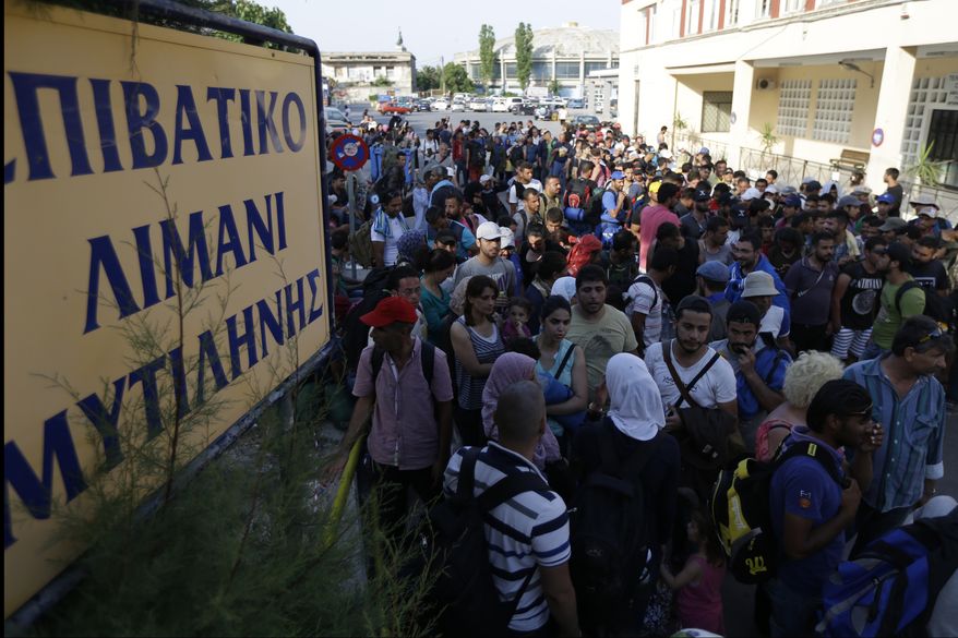 Syrian migrants who have been stranded for days, in the northeastern Greek island of Lesvos, stand in queue as they wait for travel documents from Greek authorities at the port of Mytilene on Monday, June 15, 2015. An emergency European Union plan to help Italy and Greece manage thousands of migrants crossing the Mediterranean could be vastly watered down on Tuesday, according EU diplomats. During the first five months of 2015, 40,297 migrants arrived in Greece, up from 6,500 in the same period in 2014. Almost all of them have crossed in boats from Turkey. The sign reads ''Passenger Terminal of Mytilene.'' (AP Photo/Thanassis Stavrakis)