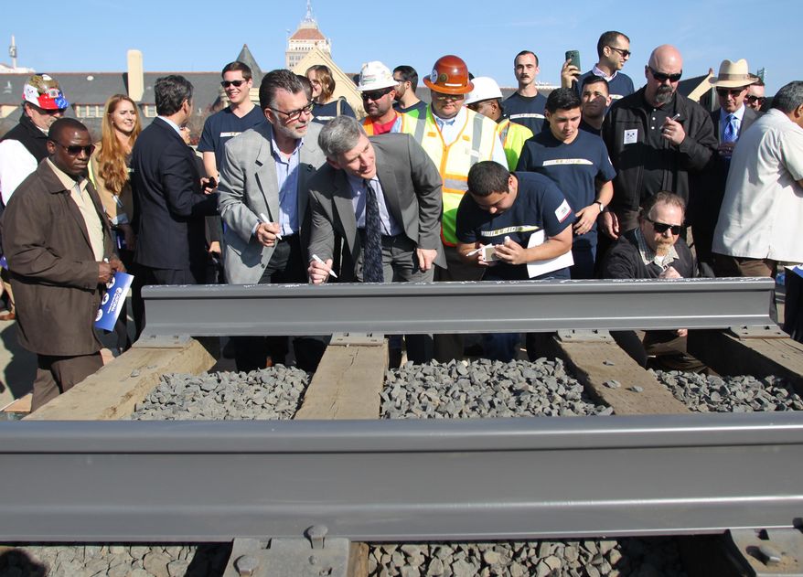 FILE - In this Tuesday, Jan. 6, 2015 file photo, dignitaries and VIP's line up to sign a portion of the rail at the California High Speed Rail Authority ground breaking event, Tuesday, in Fresno, Calif. A transportation bill passed as part of the Democratic state budget would reduce the reporting requirements for the California High-Speed Rail Authority, which critics say is a move to lessen transparency on the controversial $68 billion project. The agency that oversees the project says it brings reporting in line with its annual budgeting and reporting cycles. (AP Photo/Gary Kazanjian, File)